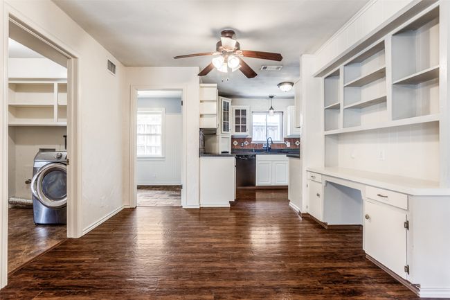 Kitchen featuring washer / clothes dryer, open shelves, a ceiling fan, dishwasher, and white cabinetry | Image 16