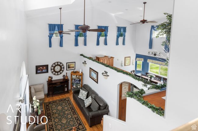 Living room with high vaulted ceiling, a ceiling fan, and wood finished floors | Image 26