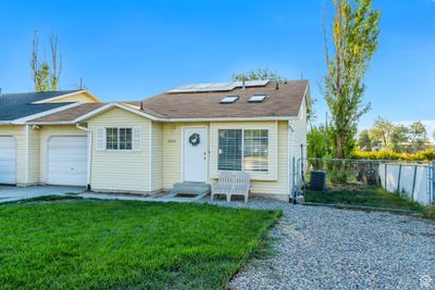 View of front facade with a front lawn, central air condition unit, and a garage | Image 2