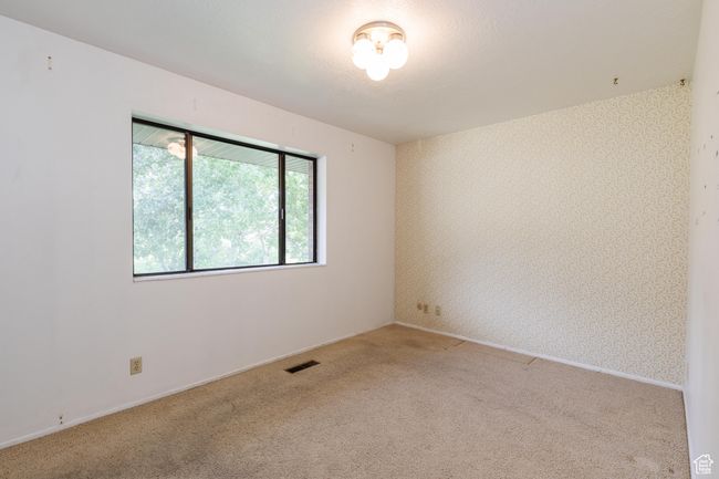 Carpeted empty room featuring wallpapered walls and baseboards | Image 14