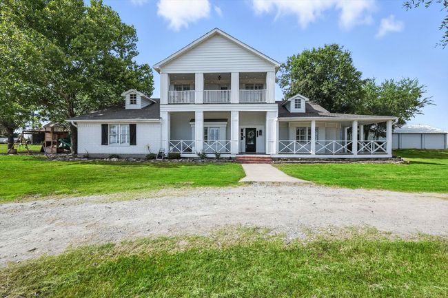Neoclassical / greek revival house featuring covered porch, a balcony, and a front yard | Image 5