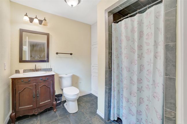 Bathroom with vanity, toilet, curtained shower, and tile patterned floors | Image 21