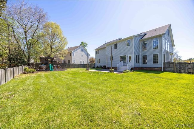 The yard is ample for games and throwing the ball for your pup dog - which is totally doable because it's also fully fenced! It's a bit hard to see, but there is a stone terrace just off the Kitchen. | Image 47