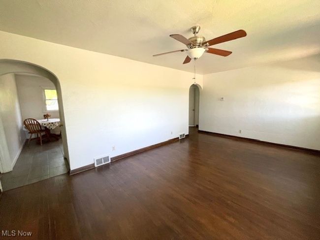 Living room featuring arched walkways, wood finished floors, shows into the Kitchen | Image 14