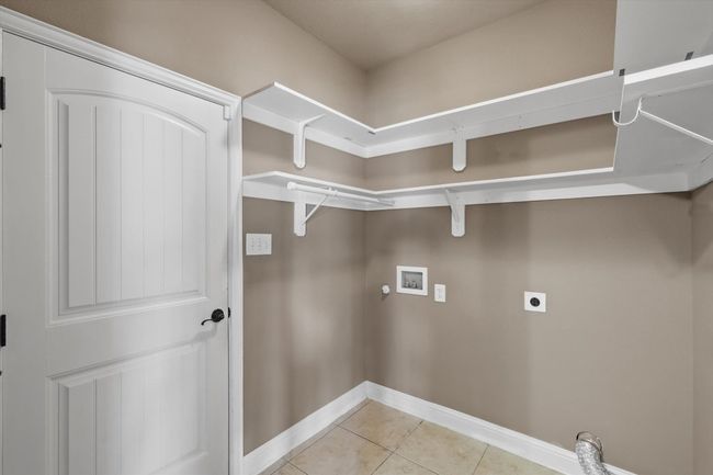 Laundry room featuring hookup for an electric dryer, hookup for a washing machine, light tile patterned floors, baseboards, and gas dryer hookup | Image 4