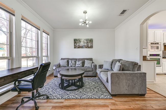 Living room featuring crown molding and a chandelier | Image 6