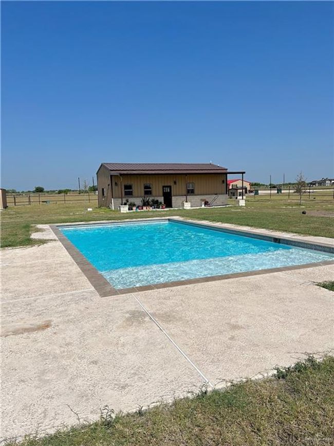 View of pool with a lawn | Image 4