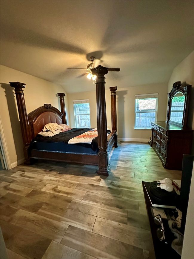 Bedroom with hardwood / wood-style floors, ceiling fan, and lofted ceiling | Image 29