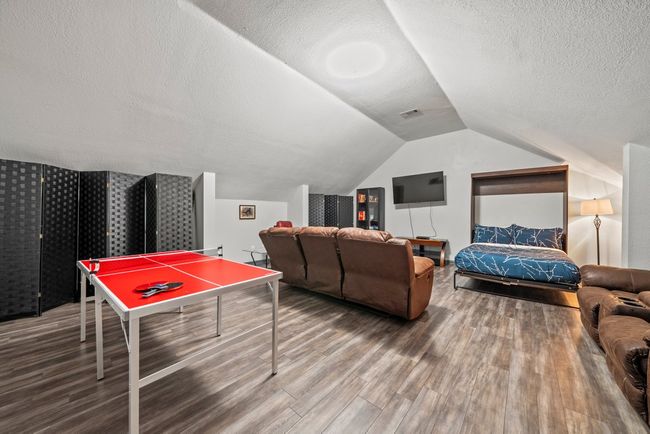 Game room featuring lofted ceiling, a textured ceiling, visible vents, and wood finished floors | Image 26