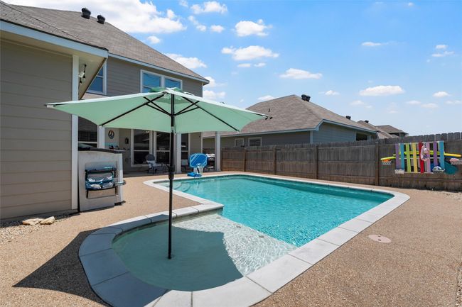 View of pool featuring a patio area, a fenced backyard, and a playground | Image 33