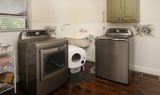 Full size utility room with access from garage or kitchen features utility sink, half bath, walk-in pantry, space for freezer and fold down ironing board. (washer & dryer do NOT convey) | Image 26