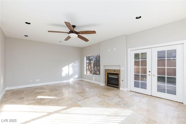 Unfurnished living room featuring french doors, ceiling fan, baseboards, and a fireplace | Image 8