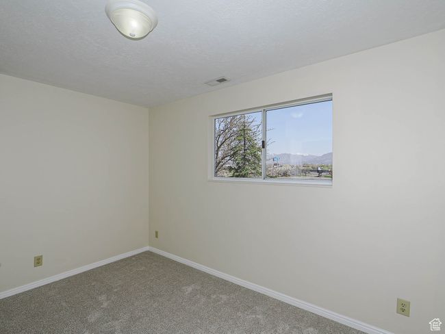 Carpeted empty room featuring baseboards and a textured ceiling | Image 44