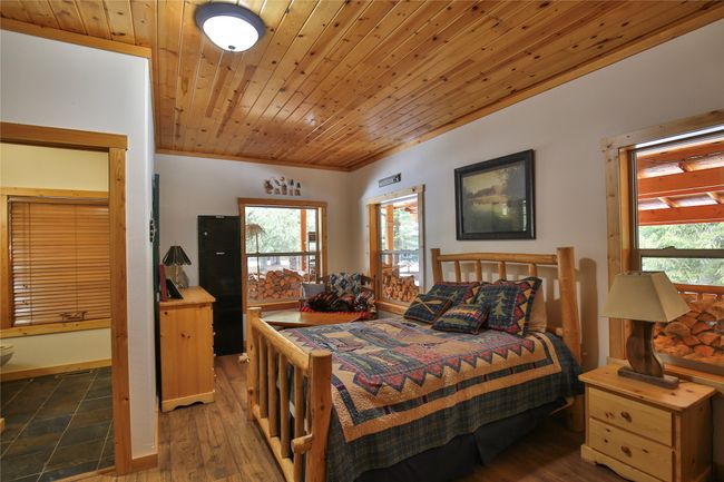 Bedroom featuring wood-look floors, multiple windows, and wood ceiling | Image 21