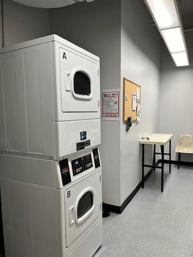 Laundry area with light tile flooring and stacked washer / drying machine | Image 11