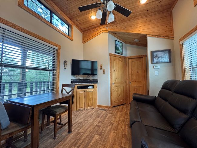 Living room with wood ceiling, light wood-style flooring, high vaulted ceiling, and ceiling fan | Image 36