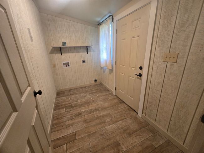Washroom with electric dryer hookup, wood finished floors, washer hookup, and wooden walls | Image 21