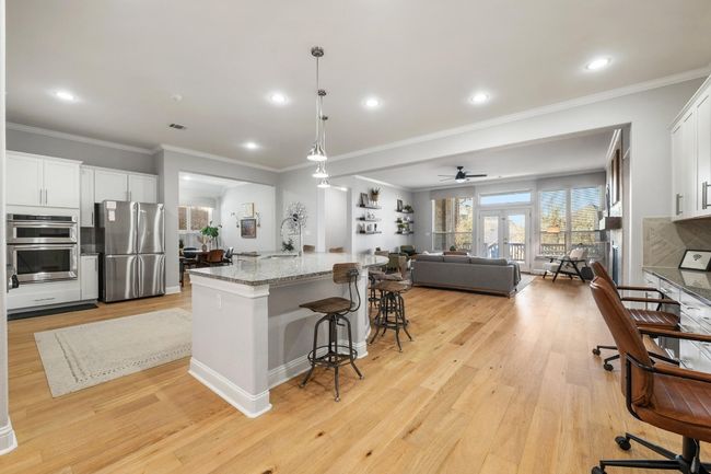 A most excellent and stunning open kitchen, informal dining area, living room and tech center with built-in desks is the heart of the home. | Image 10