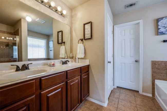 Full bathroom featuring a bath, double vanity, tiled shower, and tile patterned flooring | Image 22