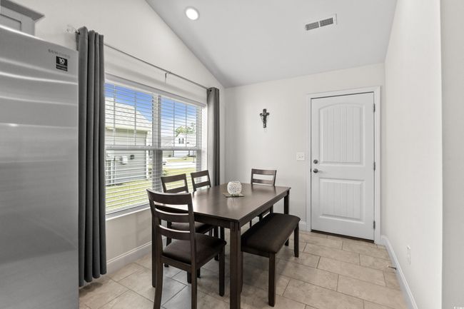 Dining space featuring lofted ceiling, baseboards, plenty of natural light, light tile patterned floors, and recessed lighting | Image 11
