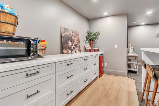Kitchen with stainless steel microwave, recessed lighting, light countertops, white cabinetry, and light colored carpet | Image 67