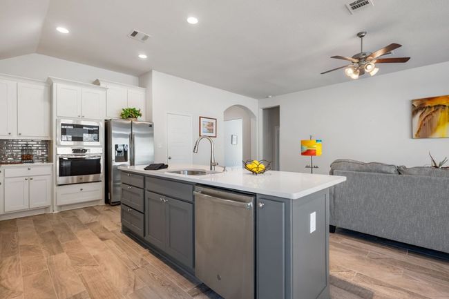Kitchen with arched walkways, visible vents, appliances with stainless steel finishes, and a sink | Image 15