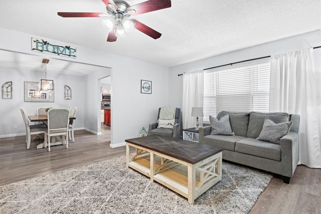 Open floor plan, Living room with wood finished floors, and a ceiling fan | Image 4
