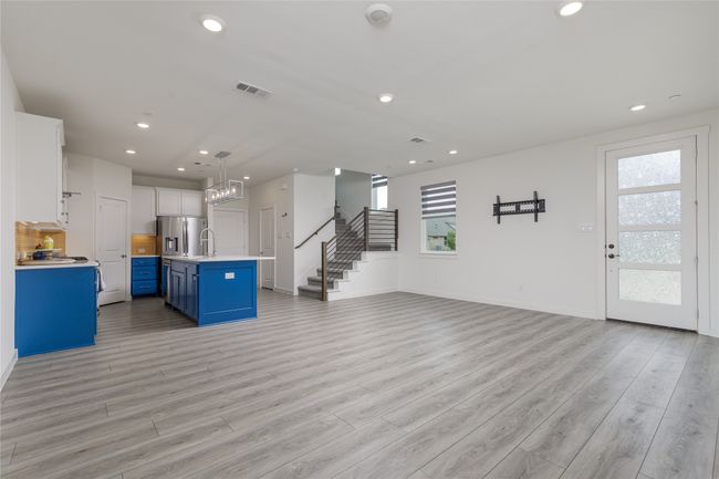 Unfurnished living room featuring plenty of natural light, recessed lighting, light wood-style floors, and stairway | Image 5