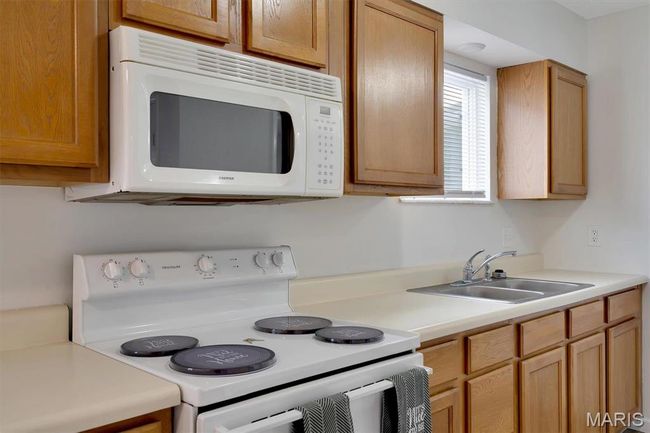 Kitchen featuring sink and white appliances | Image 6