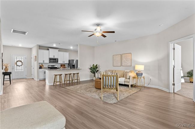 Living room with light wood finished floors, ceiling fan, baseboards, and recessed lighting | Image 22