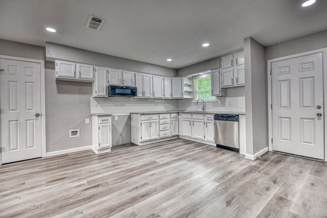 Kitchen with dishwasher, black microwave, light wood finished floors, recessed lighting, and light countertops | Image 8