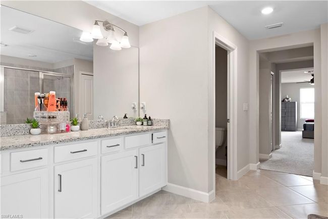 Full bath featuring vanity, toilet, tile patterned floors, a stall shower, and visible vents | Image 24