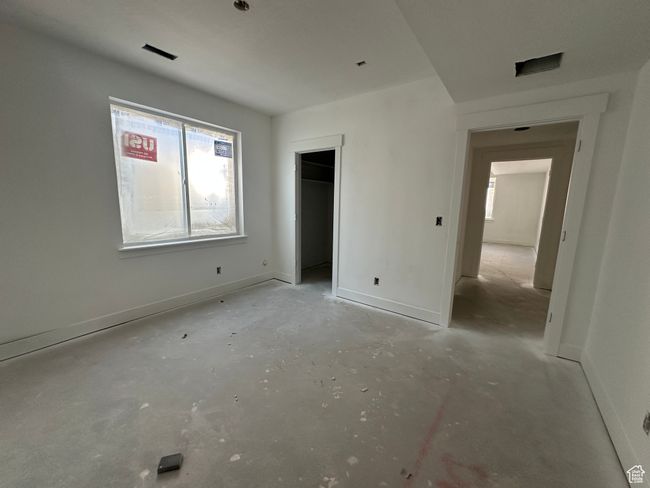 Unfurnished bedroom with multiple windows, unfinished concrete flooring, and baseboards | Image 31