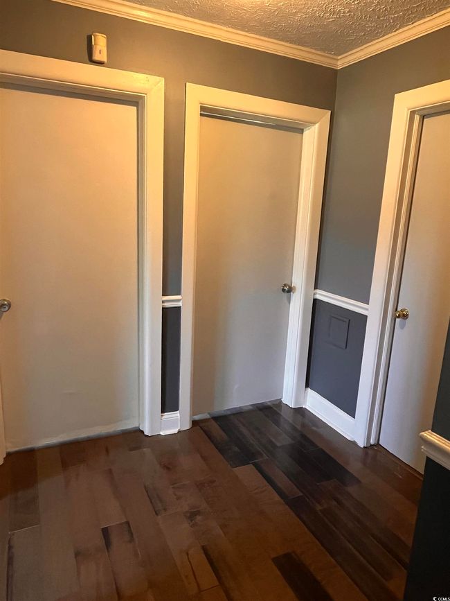 Unfurnished bedroom with wood finished floors, a closet, and a textured ceiling | Image 8