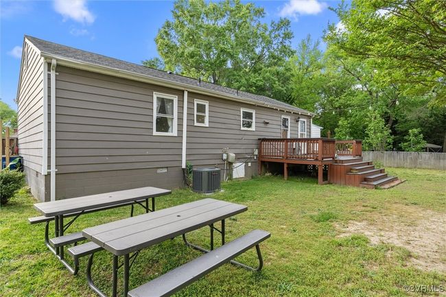 Back of property with a lawn, a wooden deck, fence, and central AC unit | Image 37