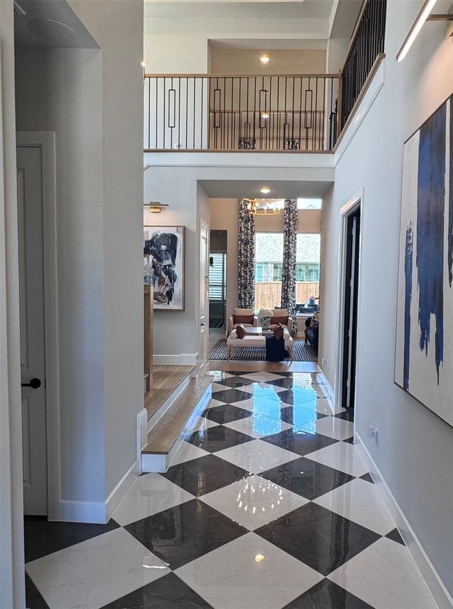 Hall featuring baseboards and a towering ceiling | Image 6