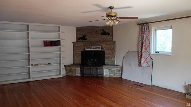Living room with ceiling fan, wood stove insert and wood-type flooring | Image 37