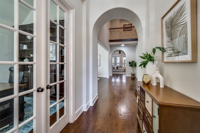 An inviting entryway welcomes you with a curved archway and hand-scraped hardwood floors that flow seamlessly throughout the main areas of the first floor. | Image 5