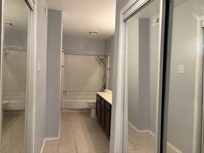 Full bath with vanity, bathtub / shower combination, and light tile patterned floors | Image 12