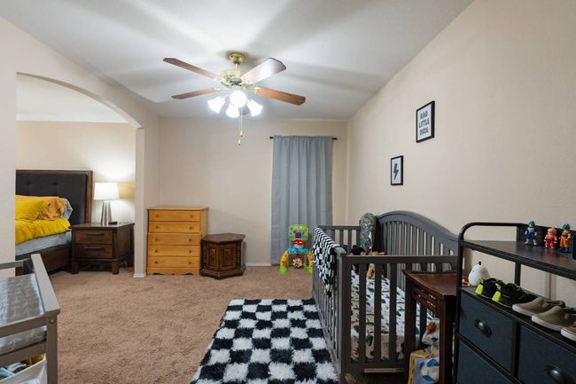 Carpeted bedroom with arched walkways, a ceiling fan, and ornamental molding | Image 15