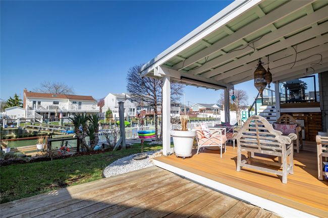 Wooden terrace with a residential view, fence, and stairs | Image 25