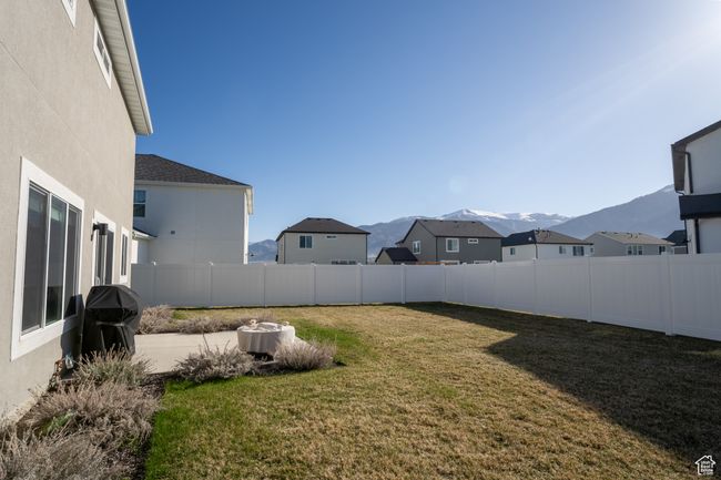 View of yard featuring a mountain view, a fenced backyard, and a residential view | Image 24