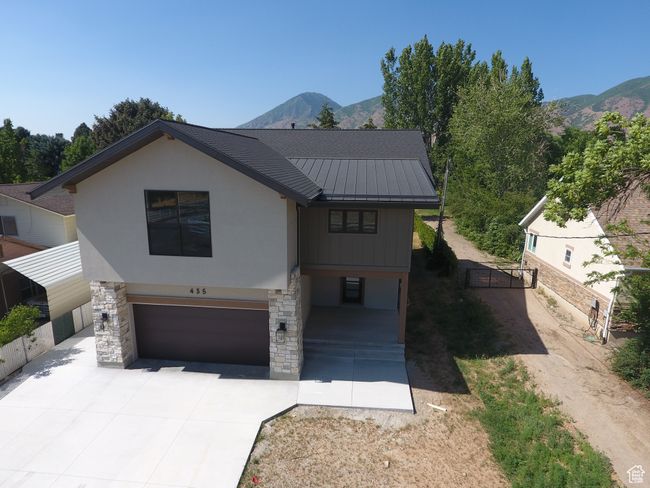 View of front facade with a garage, a standing seam roof, driveway, and a mountain view | Image 41