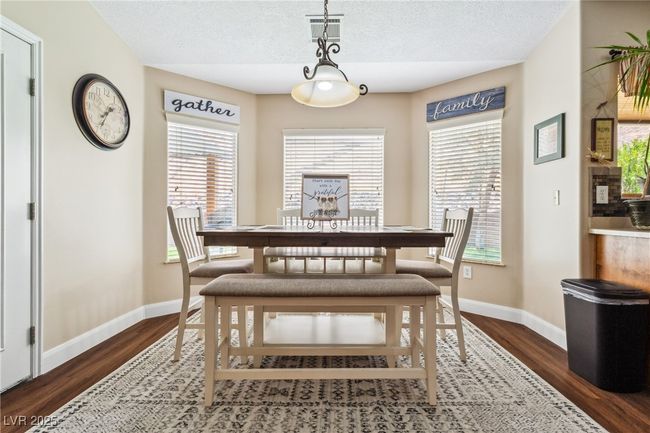 Dining room featuring dark wood-type flooring, a textured ceiling, and baseboards | Image 18