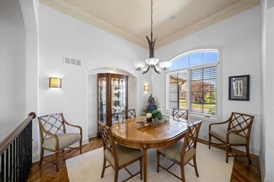 Dining space with crown molding, an inviting chandelier, and hardwood floors | Image 3