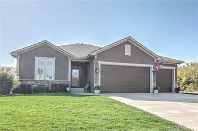 Ranch-style home featuring a front lawn and a garage | Image 2