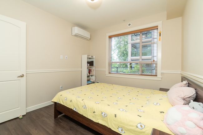 Bedroom with a wall unit AC and dark wood-type flooring | Image 25