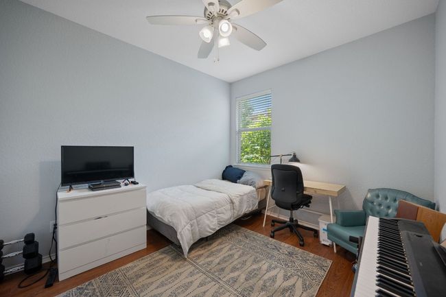 Bedroom with wood finished floors, ceiling fan, and baseboards | Image 22