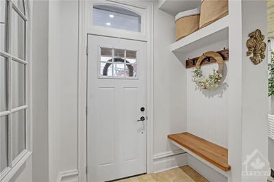 Welcoming Entry with new exterior door, stylish bench and gorgeous limestone tile | Image 2