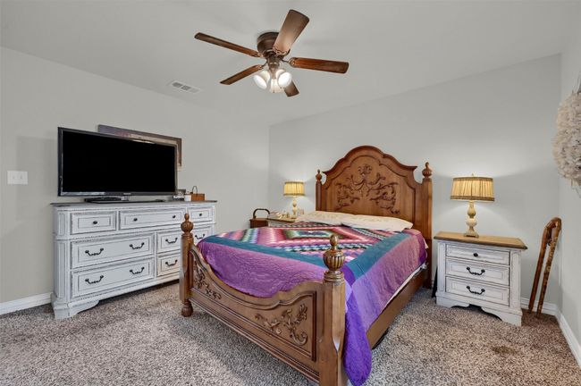 Carpeted bedroom featuring baseboards, visible vents, and a ceiling fan | Image 24